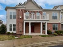 Beautiful two-story townhouse showcasing brick and siding exterior with a quaint balcony and manicured landscaping at 10330 Sablewood Dr # 103, Raleigh, NC 27617