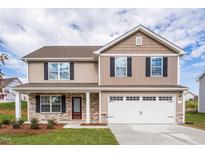Charming two-story home featuring stone accents, a two-car garage, and a welcoming front porch at 109 Wilderness Ct, Mebane, NC 27302