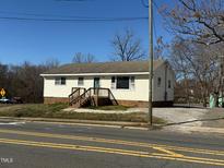 Charming single-story home featuring a welcoming front porch and a well-maintained yard on a clear, sunny day at 112 Lewis St, Oxford, NC 27565