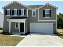 Two-story home with neutral siding, black shutters, and a two-car garage with concrete driveway at 128 Maple Tree Ln, Clayton, NC 27527