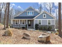 Charming two-story home with a blend of stone and siding exterior, nestled among trees with a well-manicured front yard at 130 Scarlet Oak Ln, Chapel Hill, NC 27516