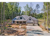 Beautiful home featuring a manicured lawn, three-car garage, and charming front porch at 140 Winsome Ln, Chapel Hill, NC 27516