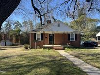 Charming brick home with a covered porch and well-maintained front yard at 1411 Hudson Ave, Durham, NC 27705