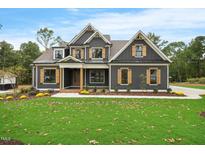 Charming two-story home featuring a beautifully landscaped yard and a welcoming covered porch at 1600 Sweetwater Ln, Raleigh, NC 27610