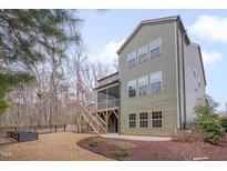 A screened porch and stairs lead to a backyard with mature trees at 1680 Mint River Dr, Apex, NC 27502