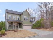 Charming two-story home with an attached garage and beautifully landscaped front yard at 1680 Mint River Dr, Apex, NC 27502