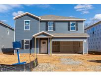 New two-story home featuring a blue siding exterior and an attached two-car garage on a construction lot at 2106 Cherry Creek Rd, Haw River, NC 27258