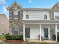Charming two-story townhouse featuring stone accents, white siding, and a welcoming front porch with gray shutters at 2356 Bay Harbor Dr, Raleigh, NC 27604