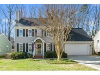 Charming two-story home with a well-manicured lawn, gray siding, black shutters, and an attached two-car garage at 2400 Dahlgreen Rd, Raleigh, NC 27615