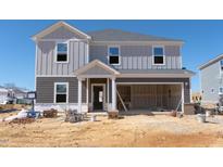 Two-story home showing gray vertical siding, open garage, and front porch under construction at 3401 Rosebush Dr, Zebulon, NC 27597
