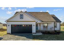 Charming home featuring a black garage door, blue front door and cozy porch with white railing at 3694 Nc-62 N Hwy, Burlington, NC 27217