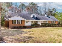 Charming single-story brick home with a well-manicured front lawn and inviting entrance at 411 E 2Nd St, Kenly, NC 27542