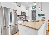 Bright modern kitchen featuring stainless steel appliances, tiled backsplash and a large island with sink at 521 N Mangum St # 12, Durham, NC 27701