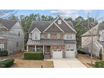 Charming two-story home with stone accents, attached two-car garage, and well-maintained landscaping at 5213 Orabelle Ct, Raleigh, NC 27606