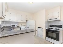 Charming kitchen featuring white appliances, bright cabinetry, and a granite countertop bar at 529 Hillsborough # H-6, Chapel Hill, NC 27514
