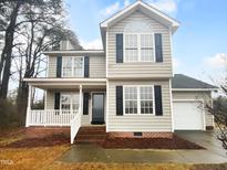 Charming two-story home featuring classic design elements, a welcoming front porch, and a well-manicured lawn at 75 Mitchell Store Rd, Youngsville, NC 27596