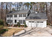 Traditional two-story white home with a two-car garage, black shutters and landscaped front yard at 10009 Bushveld Ln, Raleigh, NC 27613