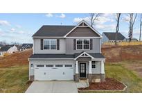 Charming two-story home featuring gray siding, a two-car garage, and a well-manicured front yard at 106 Jared Ct, Graham, NC 27253