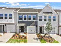 Charming townhome featuring a well-manicured lawn, a one car garage, and a welcoming entrance at 112 Central Townes Way # 294, Raleigh, NC 27603