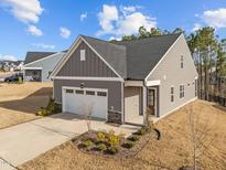 Charming single-story home boasts a gray exterior, manicured landscaping, and attached two-car garage at 1254 White Flint Cir, Durham, NC 27703
