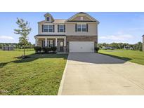 Charming two-story home featuring a welcoming front porch and attached two-car garage at 147 Young Farm Dr, Lillington, NC 27546