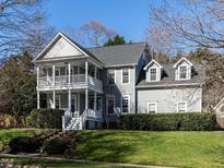 Charming two-story home featuring a double porch, manicured lawn, and traditional architecture, perfect for southern living at 2019 Falls River Ave, Raleigh, NC 27614