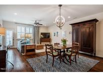 Open-concept living and dining area featuring hardwood floors and natural light at 211 Monarda Way, Hillsborough, NC 27278
