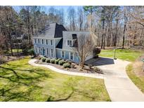 Charming two-story home with a landscaped yard and a welcoming blue front door at 2309 Laurelford Ln, Wake Forest, NC 27587