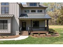 Charming front porch with black railings and metal roof offers a cozy entrance to this modern home at 3601 Bivins Rd, Hillsborough, NC 27278