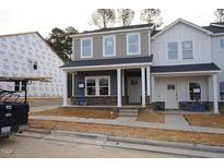 New construction two-story home featuring a brick foundation and gray siding under a black roof at 3715 Rosebush Dr, Zebulon, NC 27597