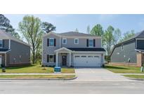 Charming two-story home with a two car garage and a well-manicured front yard at 3825 Rosebush Dr, Zebulon, NC 27597
