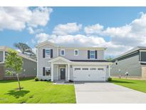 Charming two-story home with a well-manicured lawn and inviting curb appeal on a sunny day at 3825 Rosebush Dr, Zebulon, NC 27597