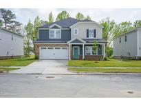 Beautiful two-story home featuring a two-car garage and covered front porch, surrounded by a lush green lawn at 3829 Rosebush Dr, Zebulon, NC 27597
