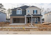 New construction two-story home featuring a brick-accented garage, inviting entrance, and modern two-tone siding at 3829 Rosebush Dr, Zebulon, NC 27597