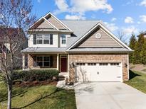 Charming two-story home featuring a stone facade, attached two-car garage, and well-manicured lawn with mature landscaping at 4 Seawell Ct, Durham, NC 27703