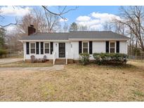 Charming single-story home featuring a well-maintained front yard and cozy front porch seating area at 5144 Shield Cir, Raleigh, NC 27603