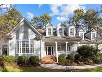 Charming home featuring light-green clapboard siding, white trim, brick accents, and a landscaped front yard at 5413 Leopards Bane Ct, Holly Springs, NC 27540