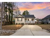 Charming single-story home featuring a cozy front porch and a large driveway, perfect for a starter home at 561 Circle Dr, Angier, NC 27501