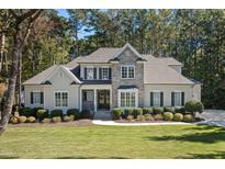 Elegant home with a stone facade, manicured lawn, and lush landscaping at 7004 Bartons Bend Way, Raleigh, NC 27614