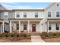 Inviting two-story townhome with a charming front porch and well-maintained landscaping at 814 Silo Park Dr, Wake Forest, NC 27587