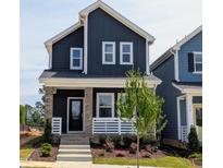 Charming two-story home featuring a welcoming front porch with beautiful landscaping and a modern color scheme at 936 Allen Park Dr, Raleigh, NC 27604