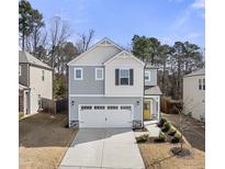 Charming two-story home boasts a yellow front door, attached garage, and landscaped front yard at 1401 Wrenn Rd, Durham, NC 27703