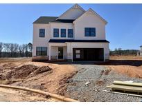 New two-story home with white siding, a two-car garage, and unfinished landscaping conveys modern suburban living at 1509 Erastus Ct # 48, Fuquay Varina, NC 27526