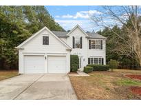 Charming two-story home boasts a classic white exterior, black shutters, and an attached two-car garage at 201 New Timber Path, Apex, NC 27502
