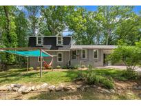 Charming gray home featuring a covered hammock area and lush greenery at 202 Brook Ln, Durham, NC 27712