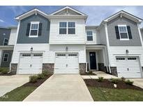 Beautiful townhome exterior showcases a two-car garage, lovely landscaping and grey and white color scheme at 26 Twin Birch Dr, Angier, NC 27501