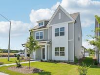 Beautiful two-story home with gray siding, white trim, and a well-manicured front lawn on a sunny day at 2880 Quarry Rd # 163, Rolesville, NC 27571