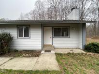 Exterior view of home featuring a white front door with two windows and a simple walkway to the entrance at 292 Cedar Lake Rd # A, Chapel Hill, NC 27516