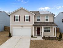 Inviting two-story home with a two-car garage, solar panels, and manicured landscaping at 3413 Dragonfly River Ct, Raleigh, NC 27604