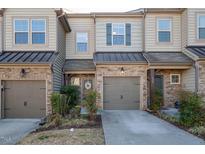 Charming townhome featuring stone accents, gray siding, and a well-manicured front yard at 345 Rubrum Dr, Hillsborough, NC 27278